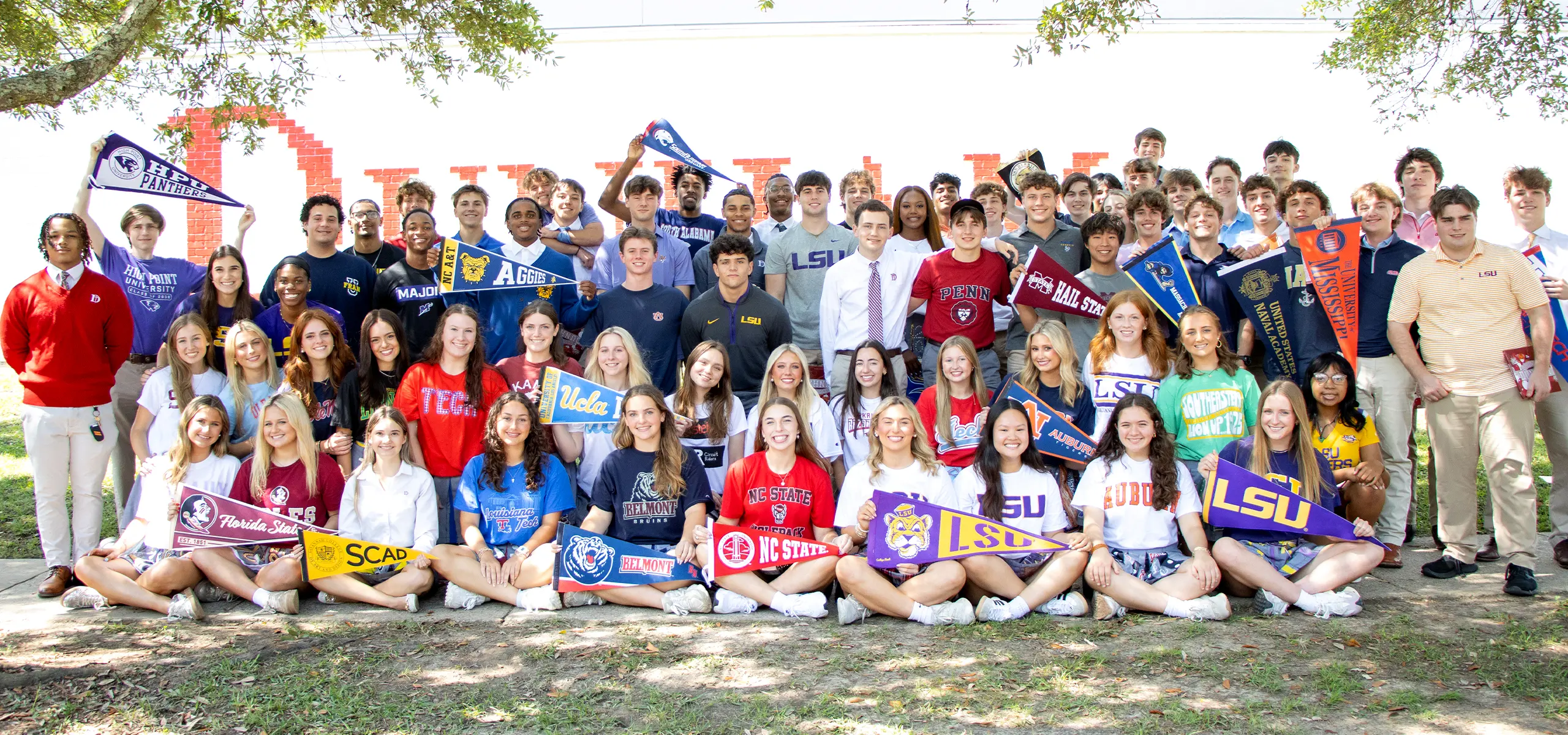 High school seniors holding their college pennants. 