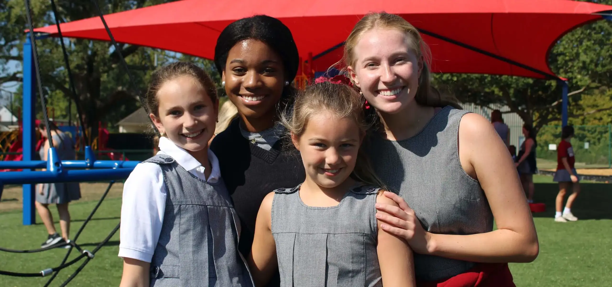 Dunham high school and lower school students smiling while playing together on new playground