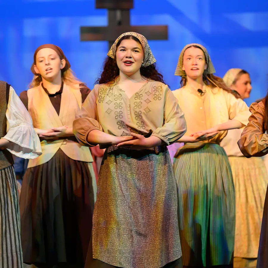 Upper school actresses singing on stage