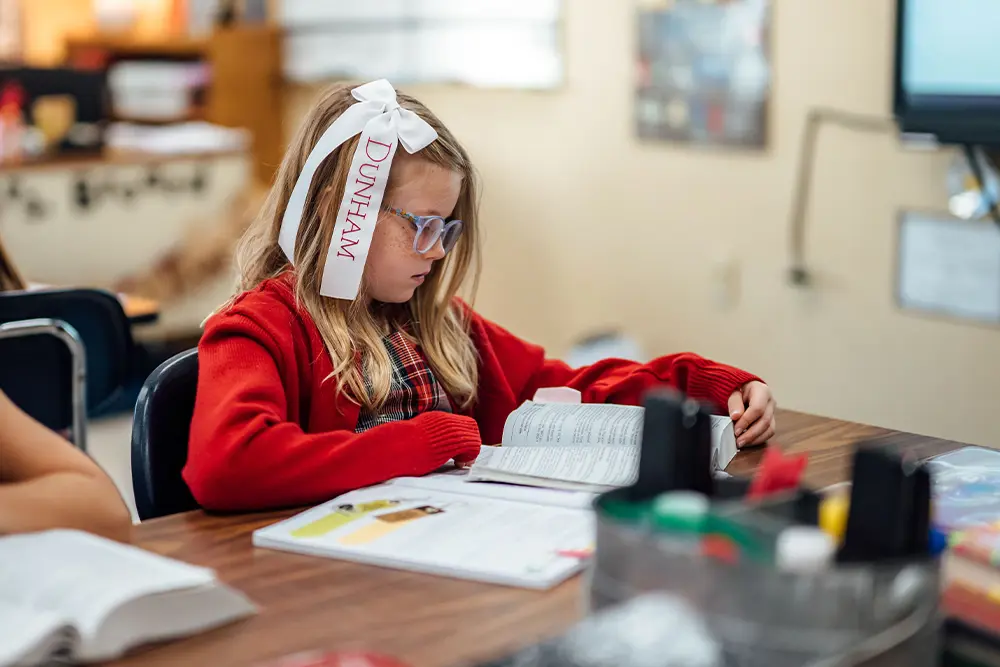 Lower school student reading the Bible