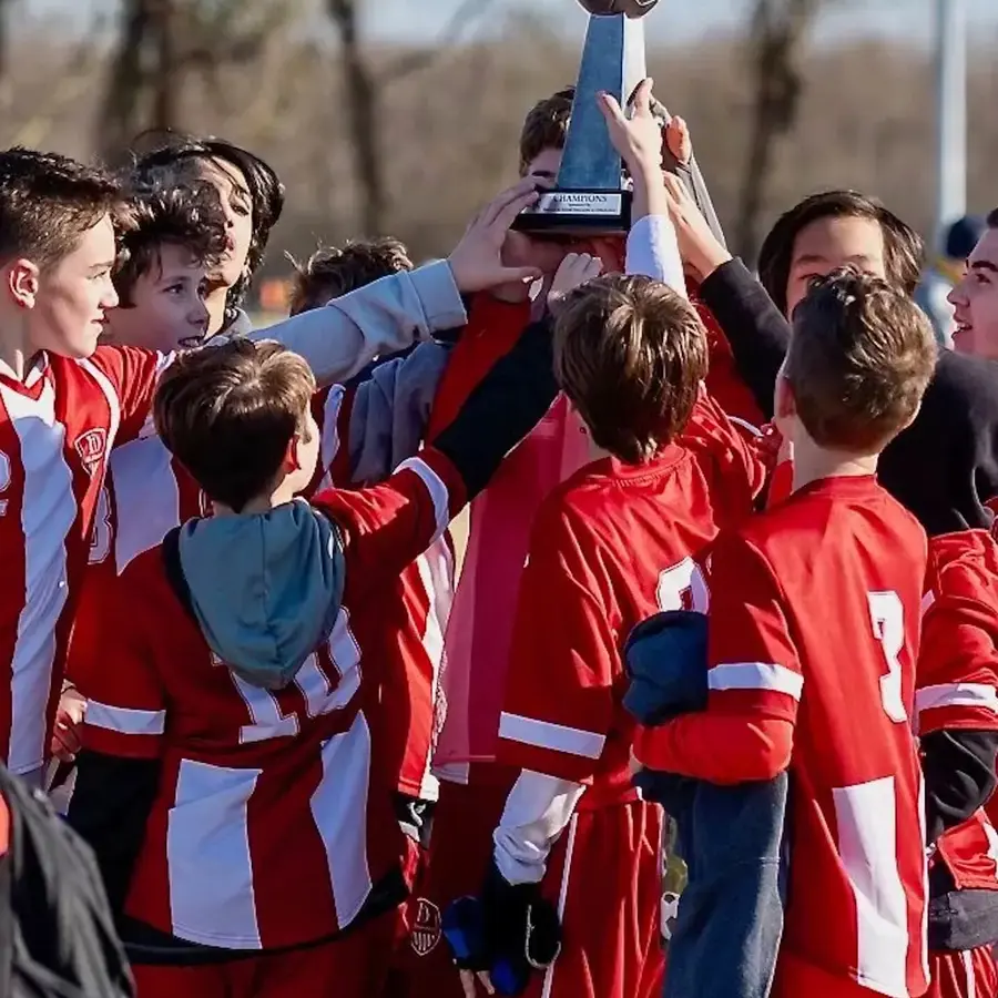 Dunham middle school boys soccer team holding up a trophy