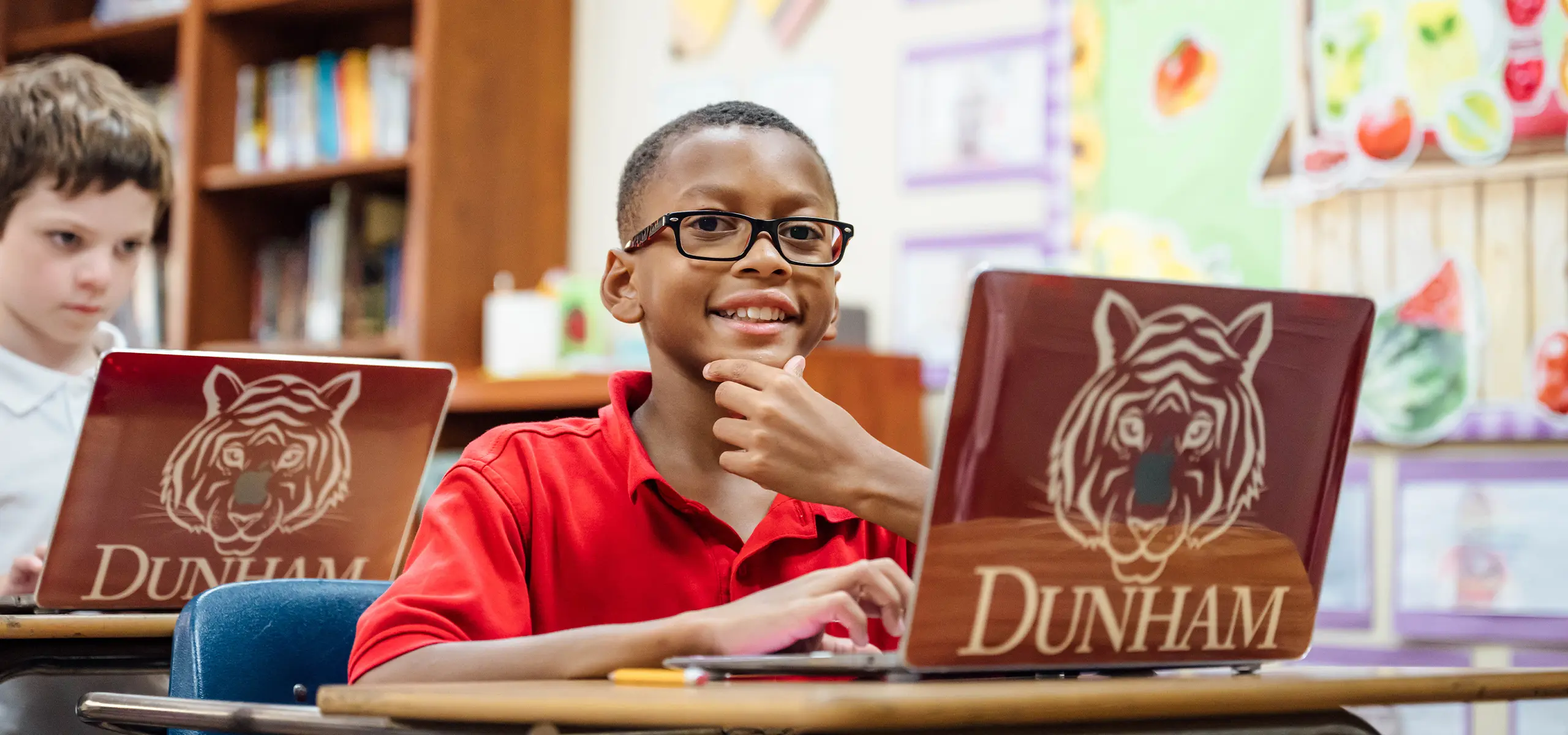 Middle school student in classroom with macbook.