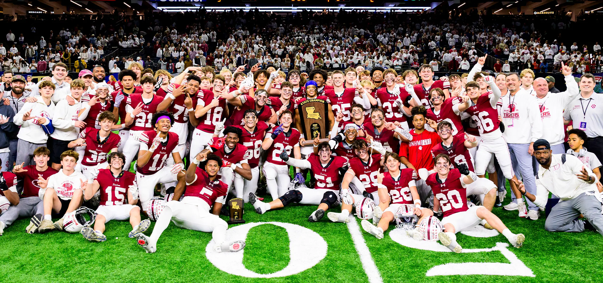 Dunham football team holding the state championship trophy