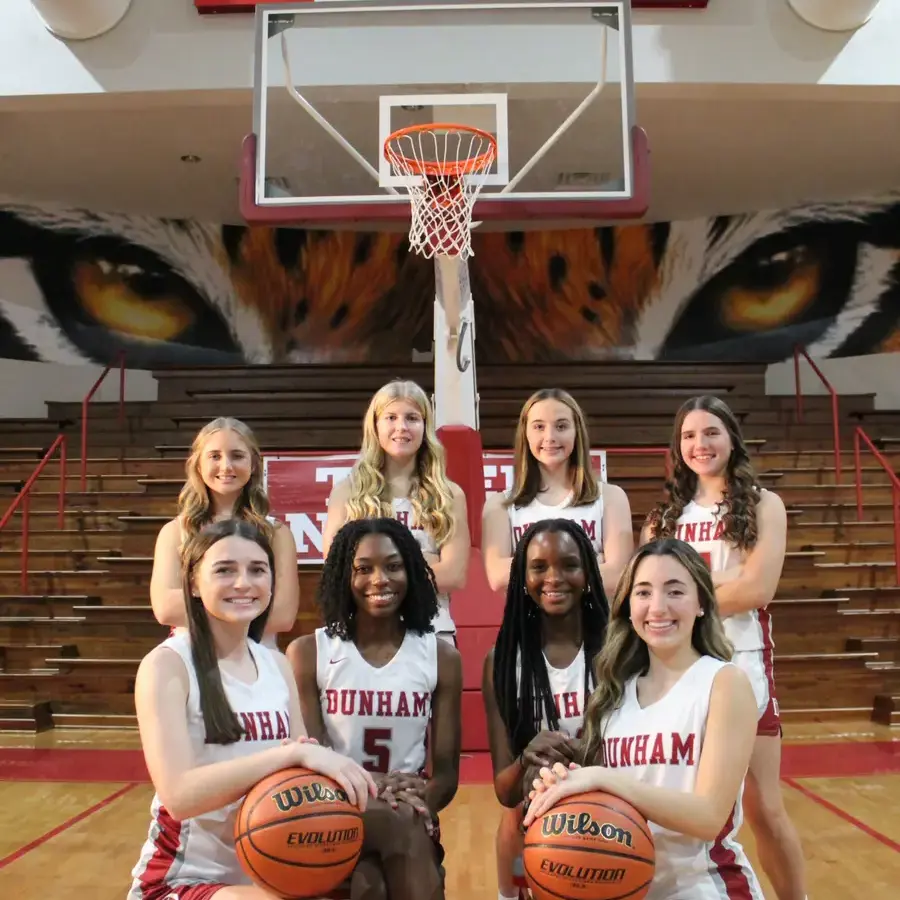 Dunham girls varsity basketball team standing together on the court